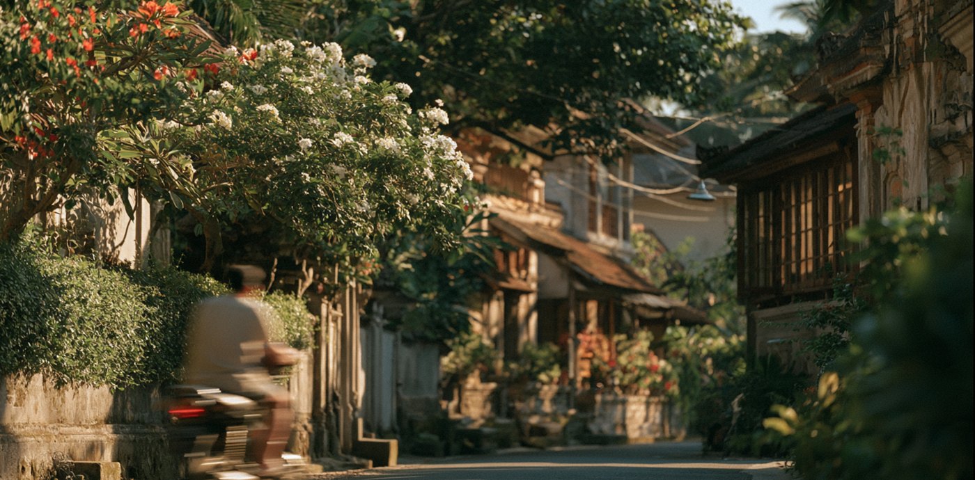 A sunlit Balinese lane with a motorbike going past